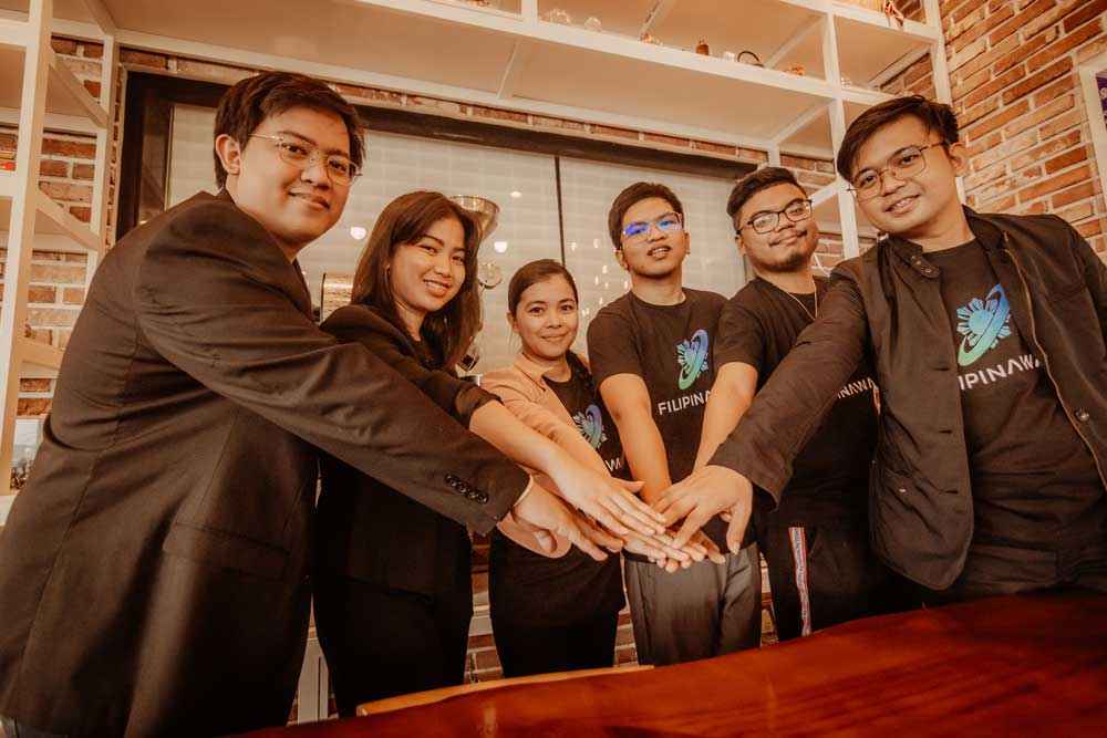 A group photo of employees putting hands together