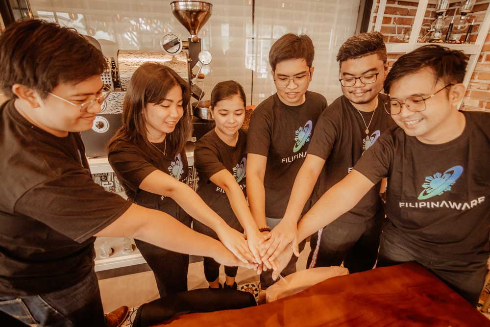 A group photo of employees putting hands together